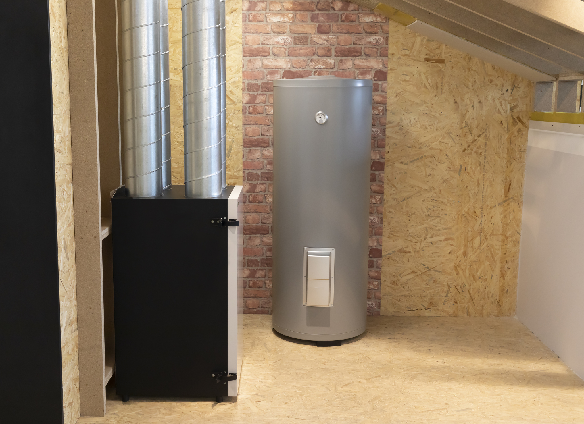 A Basement Room Houses An Efficient Water Heater Tank Next To A Ventilation System, Enhancing System Life Against The Sturdy Brick And Wood Wall.